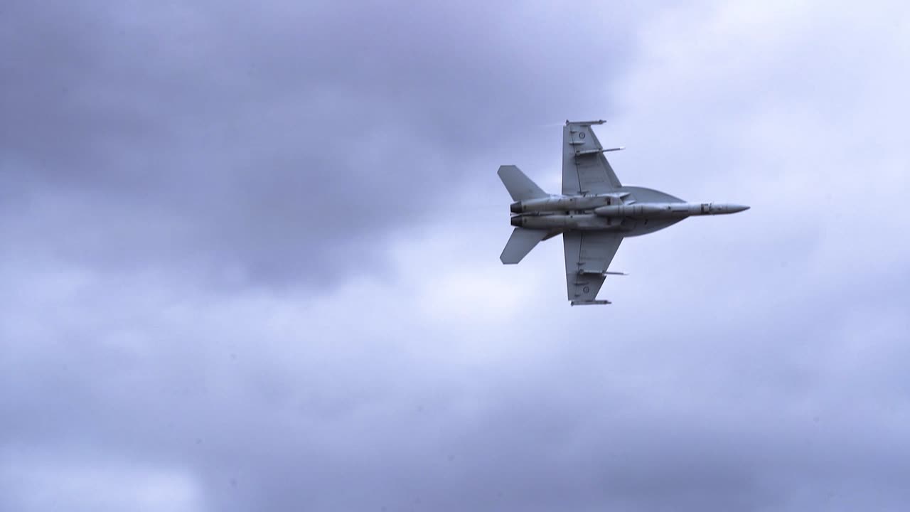 f:a-18f super hornet volando en un cielo nublado - disparo en ángulo bajo