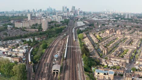 stationary drone shot of busy british rail train tracks towards london city centre