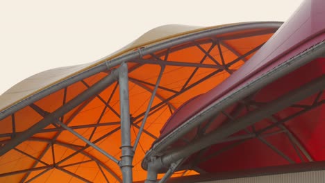 Bright-orange-and-red-roofs-of-the-Maritime-Museum-in-La-Rochelle,-France,-against-a-light-sky