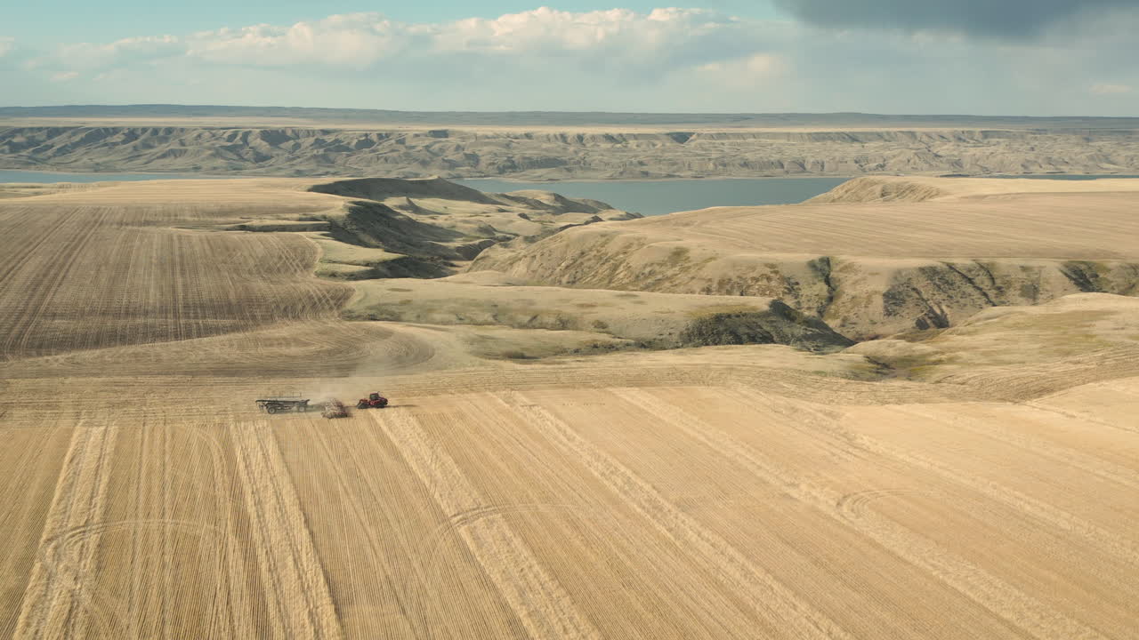 летящий навстречу тракторной технике, сажающей семена в пыльную землю в саскачеване, канада