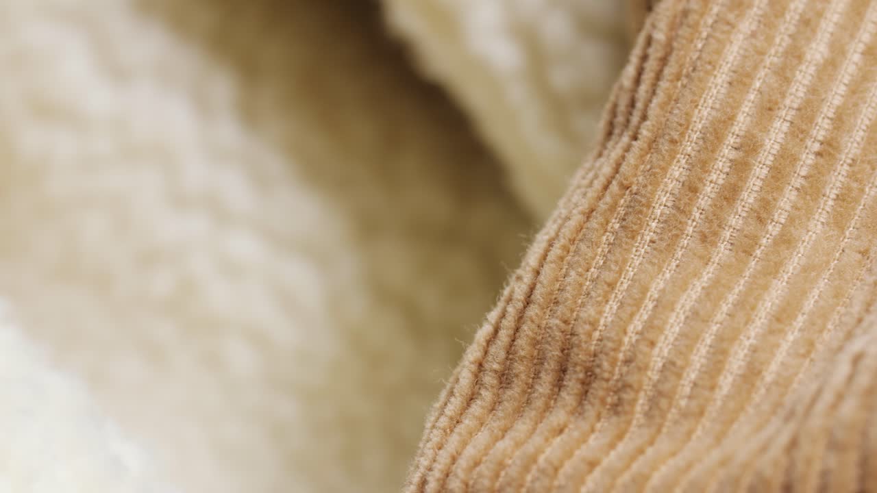 Warm beige corduroy ribs with sherpa lining, slow left-to-right macro pan