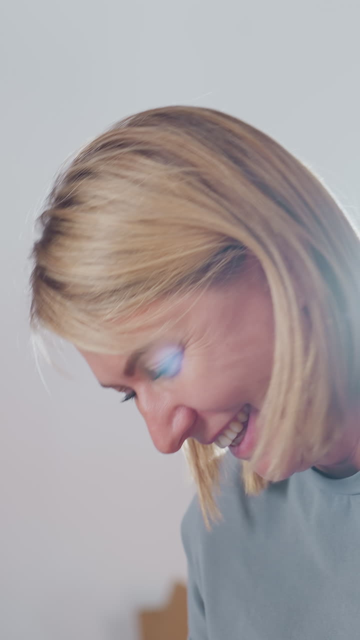 Donna caucasica sorridente che collabora con un collega, pianificazione di un progetto in un moderno studio, risate spontanee, discussione attenta, brainstorming condiviso, tutoraggio amichevole, abiti casual, luminoso