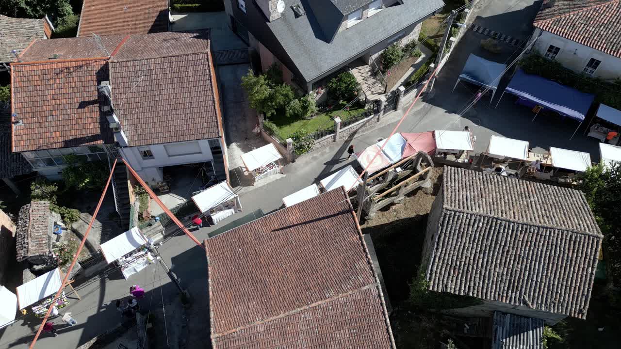 Aerial trucking pan along streets of lonoa spain, bird's eye view, ethnographic festival pereiro de aguiar lonoa spain