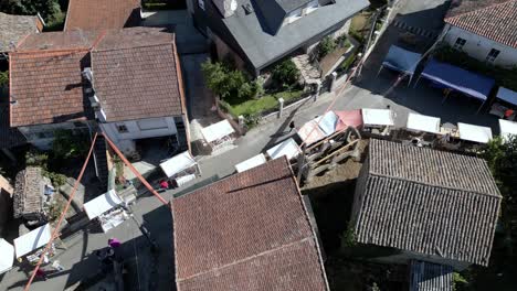 Aerial trucking pan along streets of lonoa spain, bird&#039;s eye view, ethnographic festival pereiro de aguiar lonoa spain