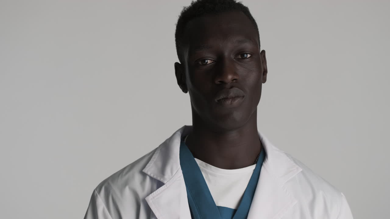 feliz médico afroamericano en el fondo gris.