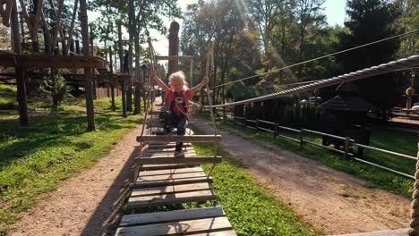 Glückliches-Kleines-Mädchen,-Das-In-Der-Tarzan-Attraktion-Auf-Dem-Spielplatz-Im-Vergnügungspark-Spielt