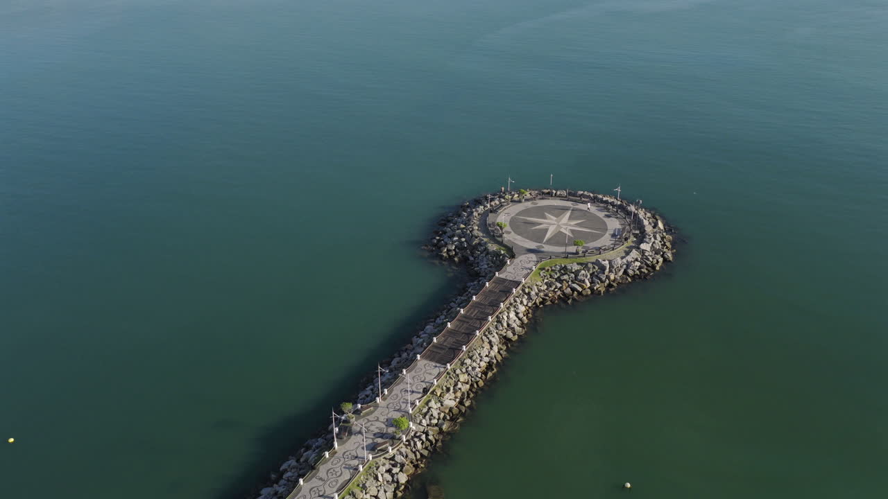Aerial view of circular Molhe da Barra Sul pier extending into the ocean from the coast, Balneário Camboriú, Santa Catarina, Brazil