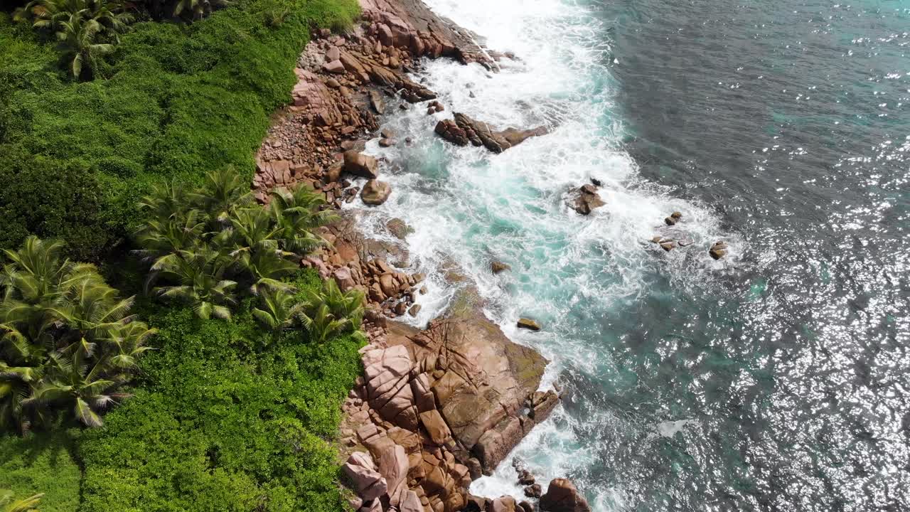 Vista aerea di onde che si infrangono sulla costa deserta ad Anse Songe a La Digue, un'isola delle Seychelles.