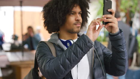 Happy-student-on-campus-taking-pictures