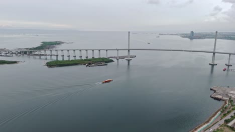 aerial de un barco que se dirige bajo la autopista de enlace cub-cordova en cebu - filipinas