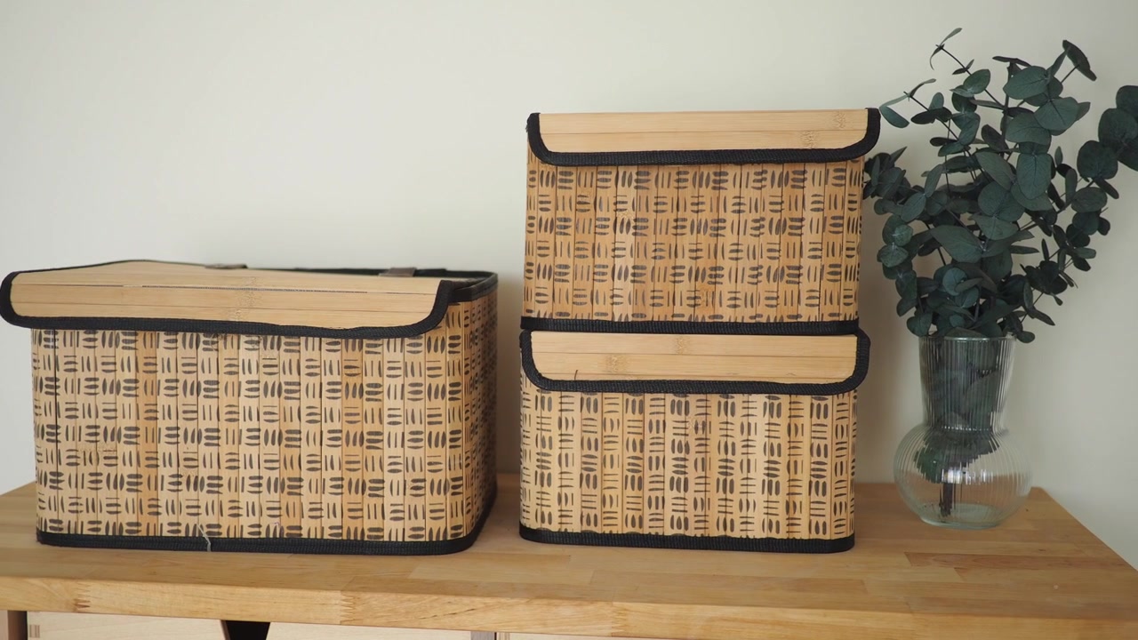 Cajas de almacenamiento de bambú natural con decoración de eucalipto sobre superficie de madera