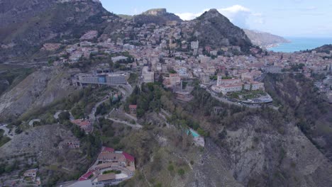 aerial establishing shot of taormina, sicily, italy a south side of the city on the volcano