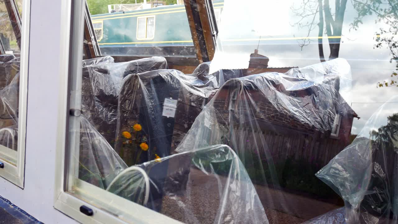 코비드 대유행 기간 동안 영국 운하에서 비어 있는 관광 바지선에 비닐봉지가 덮힌 좌석