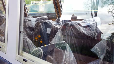 plastic bag covered seating on tourist barge boat waiting empty on british canal during covid pandemic