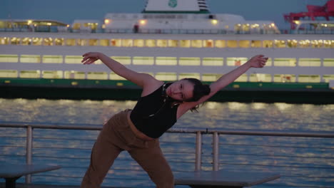 Young,-female,-contemporary-dancer-on-pier-at-night