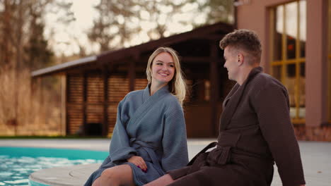 happy family pair is resting in countryside thermal spa complex relaxing near thermal outdoor pool