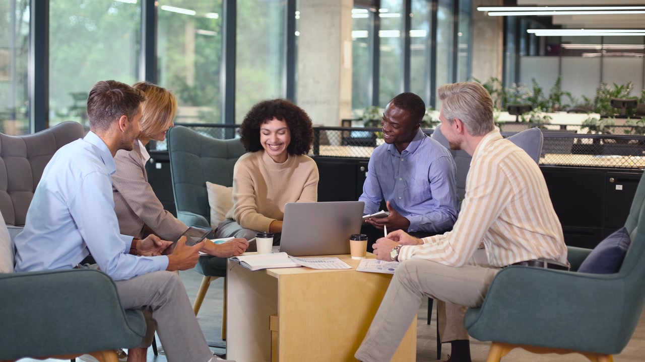 Equipe de Negócios Diversificada Colaborando em um Lounge de Escritório Moderno