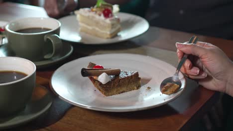 frau genießt ein stück kürbis-brownie-creme-torte-dessert, frauen-hände essen kuchen-desserts