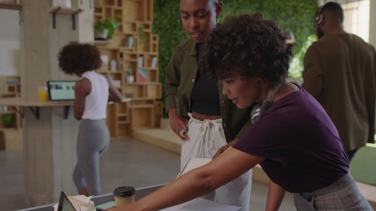 professional black business women brainstorming creative team sharing ideas enjoying collaborating colleagues working together in trendy office workplace