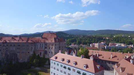 Dramatic-aerial-top-view-flight-old-town-city-Krumlov-Cesky-castle-on-the-hill-castlein-in-czech-republic-in-Europe,-summer-of-2023