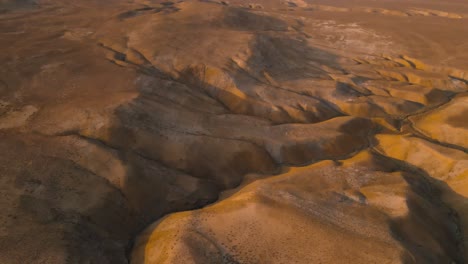 drone shot flying over the desert landscape in the qobustan national park in azerbaijan at sunset while panning up