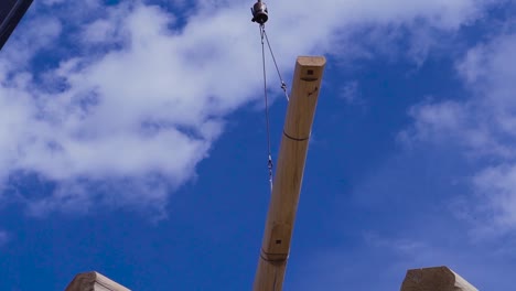 crane lifting a large wooden beam