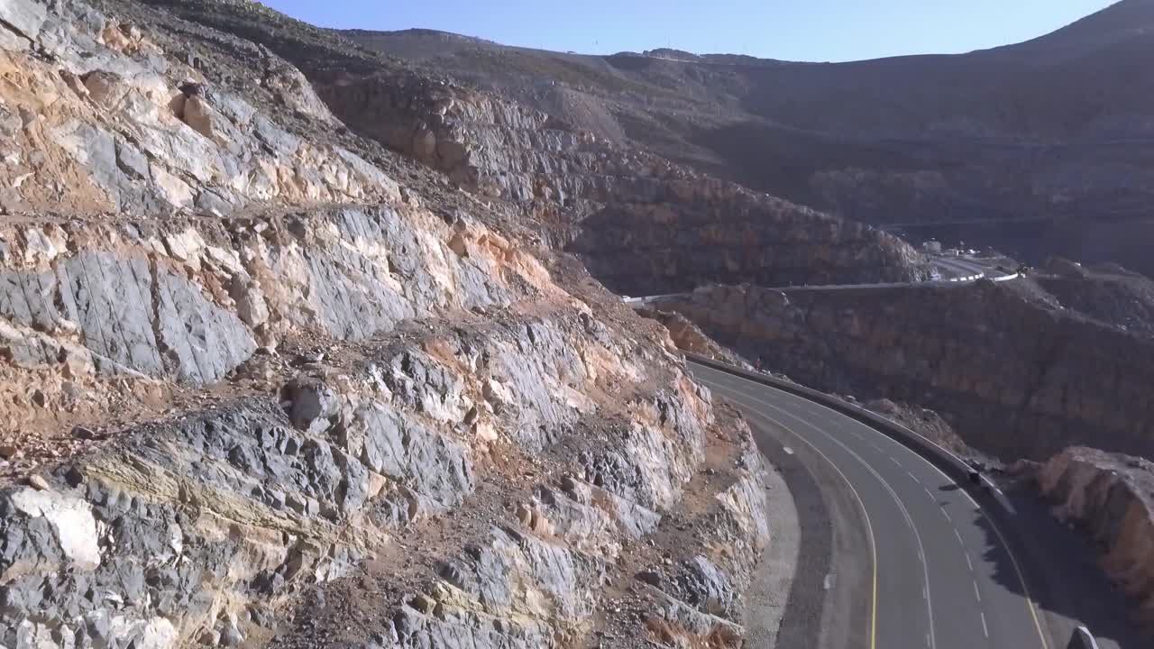 la vista superior de las imponentes montañas rocosas en jebel jais emiratos árabes unidos que casi alcanzan el cielo azul brillante en un día soleado - toma amplia