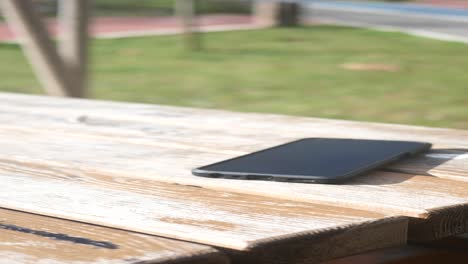 smartphone on a wooden table in a park