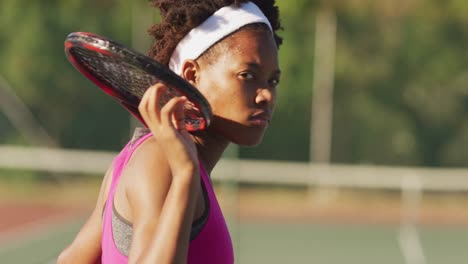 Video-of-african-american-female-tennis-player-holding-racket-and-looking-at-camera