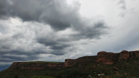 Moluti-sandstone-cliffs-at-the-border-of-Lesotho-in-South-Africa-at-the-Camelroc-travel-guest-farm,-stunning-thunderstorm-clouds,-most-amazing-mountains-and-green-scenery-landscapes