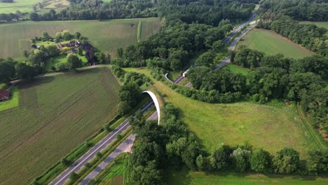 dutch landscape with road traversed by wildlife crossing forming a safe natural corridor bridge for animals to migrate between conservancy areas. environment nature reserve infrastructure eco passage.