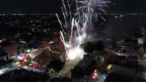 aerial zoom out view from above of fireworks coming out from the ground in the city at night