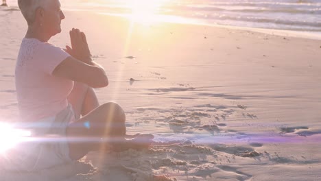 animation of light spots over caucasian woman practicing yoga at beach and meditating