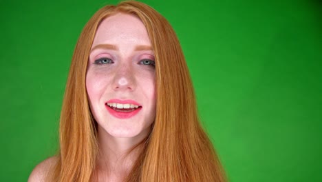 a close up portrait of a beautiful young white woman, smiling and looking straight into camera