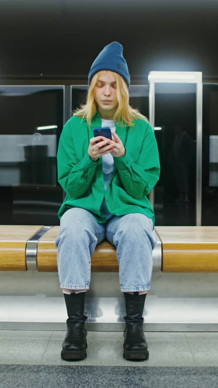 Donna che usa il telefono sulla banchina della metropolitana