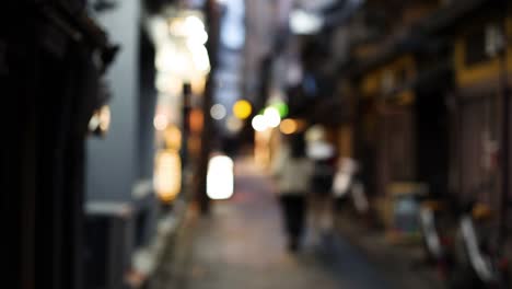 조명 된 골목길 을 고 있는 초점 이 벗어난 인물 들