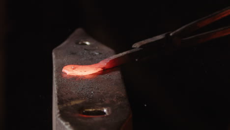 a red hot iron being hammered on an anvil by a blacksmith. 240fps slow motion