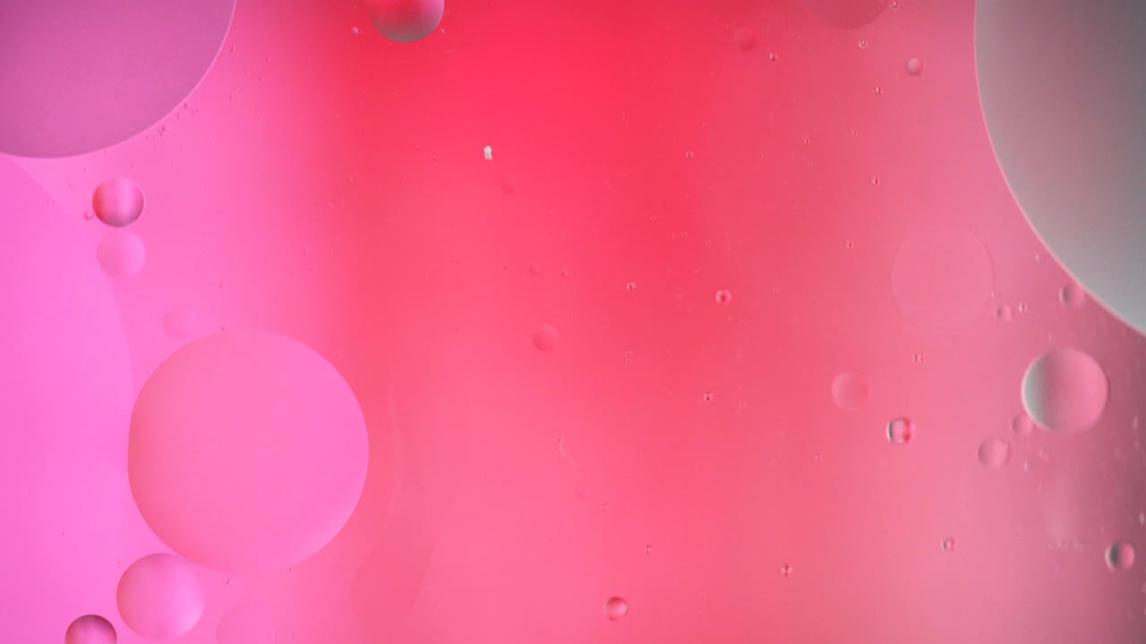 Fantastic structure of colorful bubbles. Chaotic motion. Abstract colorful paint. Top view. Movement of bubbles in the liquid. Oil surface multicolored background. Macro