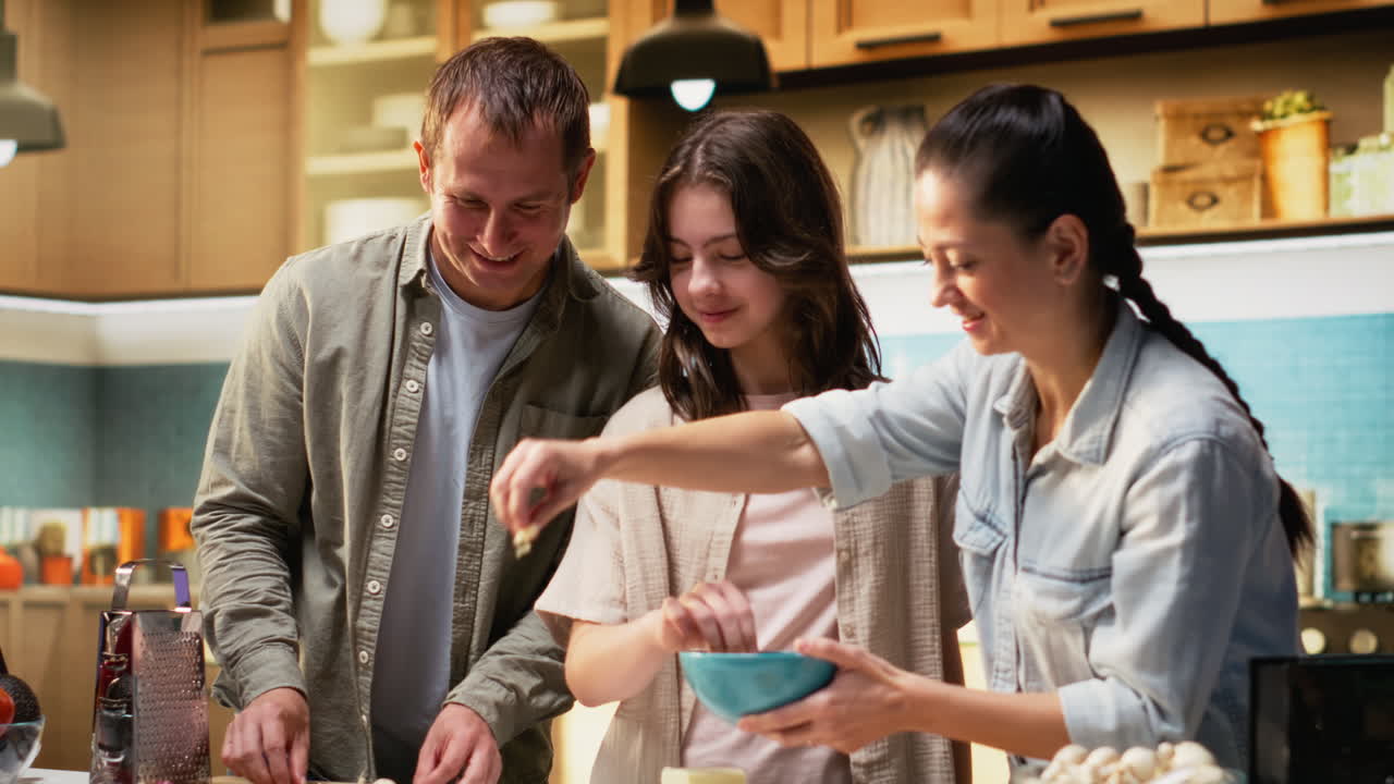 Family fun in the kitchen as everyone is layering cheese and mozzarella