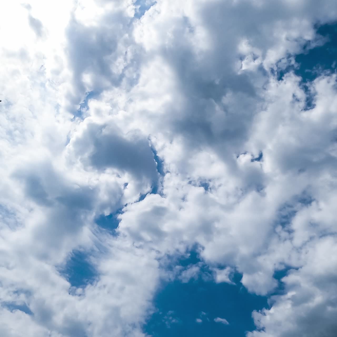 Lovely clouds gathering in the sky. Cloudscape transformation on summer sunny day in blue skies. Timelapse