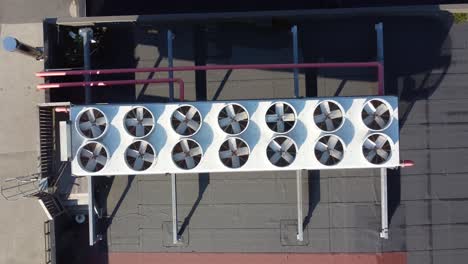 industrial ac system with 14 fans on rooftop at sunny day - top-down ascending aerial from closeup to overview