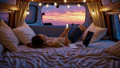 woman relaxing in a campervan at sunset
