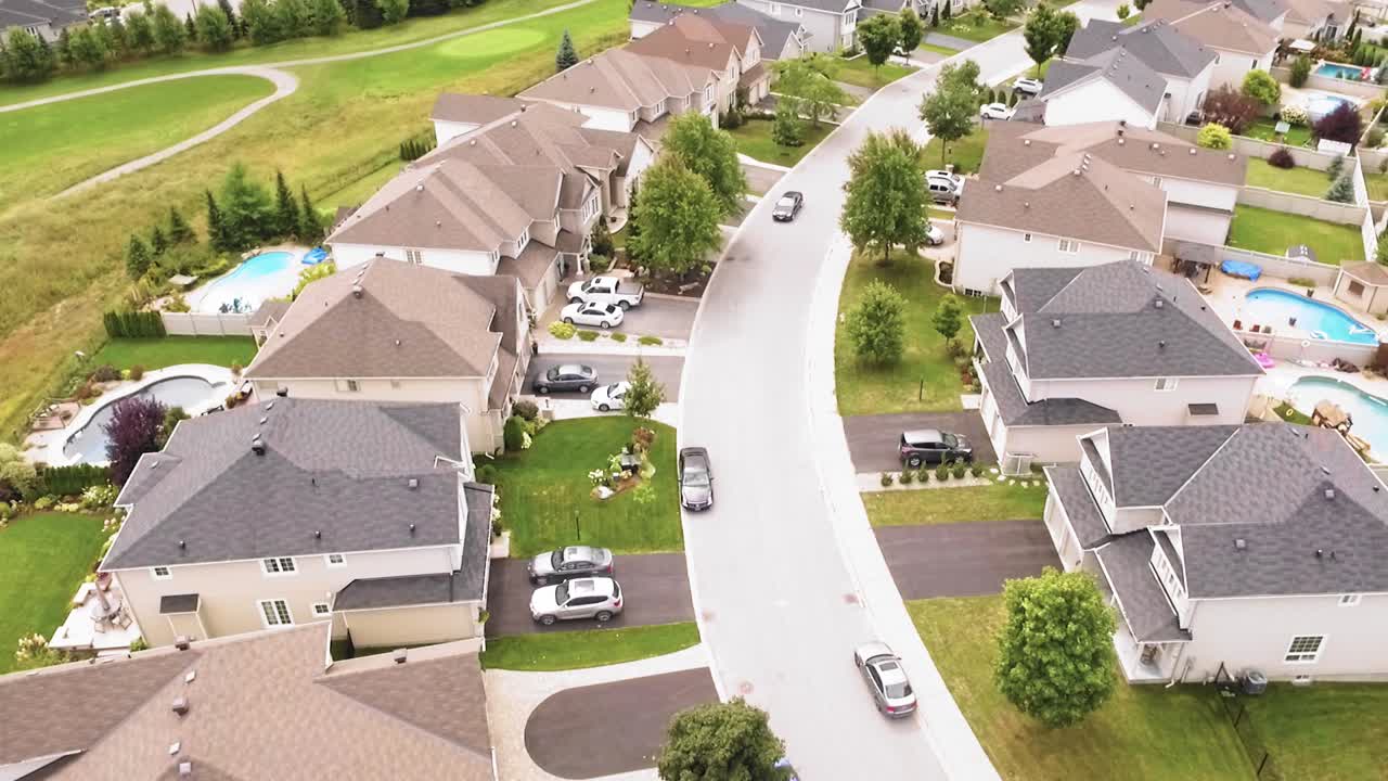 impresionante toma aérea inclinada de un estacionamiento de automóviles en su casa en un vecindario suburbano bien cuidado