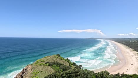 aerial view of waves hitting a sandy beach