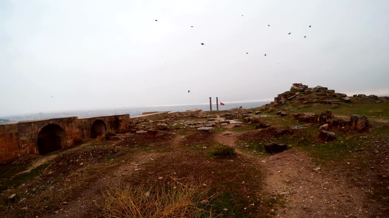 dentro de las ruinas del castillo de urfa lejos dos columnas pájaros vuelan nieve y lluvia
