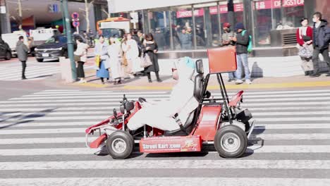 costumed drivers navigate go-karts across crosswalk