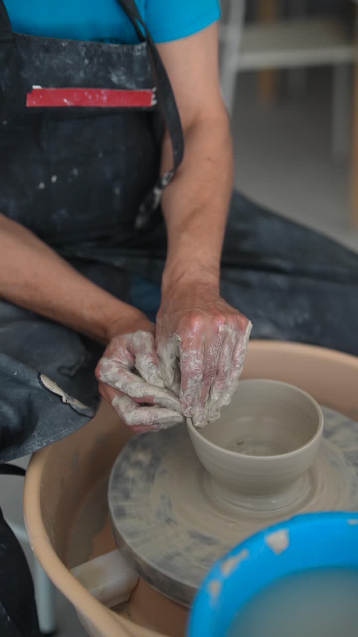 manos moldeando arcilla en la rueda de un alfarero