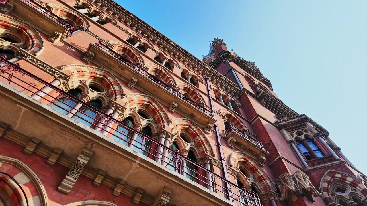 Hermosa panorámica en ángulo bajo de la fachada con ventanas y balcones del histórico edificio del hotel y estación de tren St Pancras de Londres, en Londres, Inglaterra, en un soleado día de verano