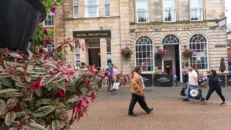 people walking past shops and hotel reception