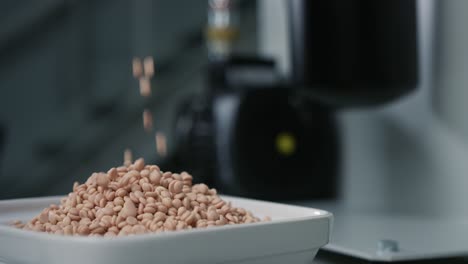 slowmo of granulate for an industrial coolant beeing poured into a white bowl next to a milling machine